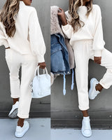 Beige nahtloses T-Shirt in weichem, leichtem und komfortablem Design worn by a person standing, highlighting the sleeves and waist fit, with neutral background.