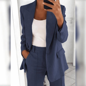 Woman wearing a chic blue tailored blazer and high-waist trousers set in dunkelblau color, size 3XL, standing with hands by her sides