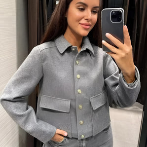 A woman wearing a chic metallic silver-gray blazer with a glittery finish, styled for an evening look.