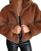 
A close-up image of a women's beige teddy jacket in a soft fleece material, featuring a zip-up design with a high collar. The jacket is shown in a brown color variant, size 5XL. The focus is on the texture and style of the outerwear, emphasizing the cozy and fashionable aspects.