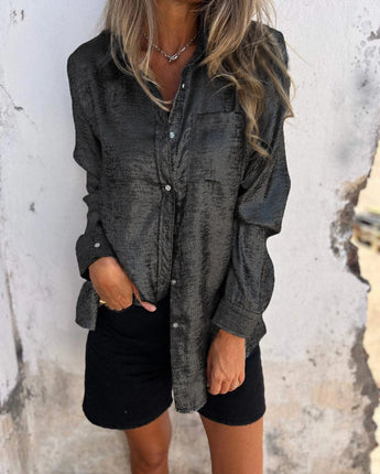 
A woman wearing a metallic silver blazer styled for a fashion party. The blazer has long sleeves and is paired with black shorts. She is standing confidently, showcasing the elegant and shiny texture of the jacket. The outfit is suitable for a fashionable event, combining modern style with a touch of sophistication.