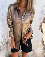A metallic silver blazer designed for women, styled as a fashion party jacket, in a large 5XL size, featuring a combination of silver shades with brown undertones. The blazer includes details such as a structured collar, long sleeves, and a tailored waist, highlighting the shoulder and neck area, suitable for elegant occasions.