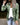 Olive green military-style jacket for women in size 3XL, featuring a collared design with long sleeves and multiple pockets, styled with jeans for a casual outerwear look.