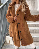 Long brown teddy coat for women in a fashionable winter style, featuring a cozy and warm design with a focus on outerwear. The coat has a classic overcoat cut with long sleeves, suitable for cold weather. The color appears as a coffee shade, providing a stylish and versatile look for winter attire.