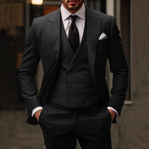 A man wearing a dark gray double-breasted suit, tailored for luxury business fashion, with black trousers and a dress shirt, shown in flash photography.