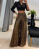 Goldene Pailletten-Hosen mit weitem Bein, die elegant und glänzend wirken, ideal für Abendmode-Anlässe, getragen von einer Person.