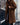 
A woman wearing a long blue teddy coat, showcasing a cozy and fashionable winter style. The coat is fluffy with a tartan pattern, covers the shoulders and knees, and features long sleeves. She pairs the coat with eyewear, adding a chic touch to her winter outfit.