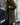 
A long, blue teddy coat for women, featuring a plush and fluffy texture, styled in a winter fashion. The coat is shown in a relaxed green variant, size XL, with features such as a wide collar, long sleeves, and a knee-length design.