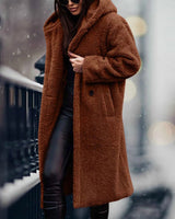 Long rust-brown teddy coat for women in XL, featuring a plush, fuzzy texture, modeled standing with visible shoulders, neck, sleeves, and a knee-length hem, exemplifying stylish winter fashion.