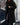 
A long black teddy coat for women in XL size, featuring a fluffy texture and designed for winter fashion. The coat resembles an overcoat or trench coat style, highlighting areas such as shoulders, neck, sleeves, waist, knees, and thighs.