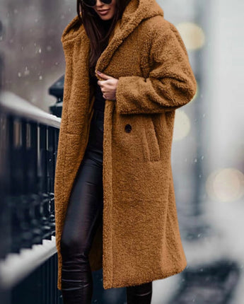 
A long blue teddy coat for women with a fluffy texture, featuring a tartan pattern and a fur-like appearance. The coat includes a collar, long sleeves, and extends to the knees, suitable for winter fashion. Modeled in the "Goldenes Kamel" color variant, size XL.