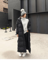 Damen Oversized Maxi Winterjacke, langer schwarzer Daunenmantel mit langen Ärmeln und Kapuze, ideal für kühle Wintertage, modernes Design.