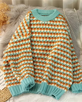 Damen Pastell Strickpullover in Hahnentritt Muster mit Türkis, Pink, Grün und Blau Farben, kuscheliger Winterpulli in Größe 3XL, auf einem Kleiderbügel.