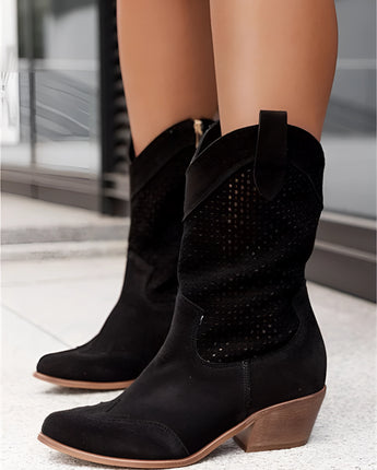 Weiße perforierte Damen Cowboy Stiefel in Sommer Western Ankle Boots Stil, getragen von einer Person, die weiße Schuhe und weiße Jeans trägt.